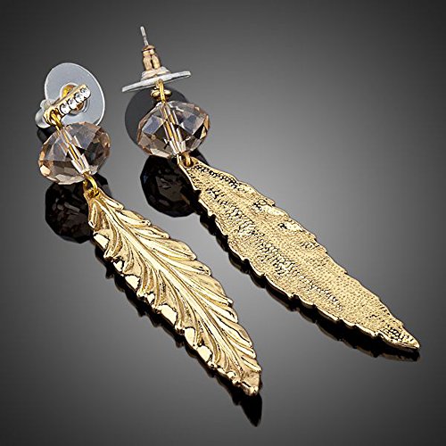 At the base of these earrings are large swarovski crystals which appear amber in colour. In the centre of the crystals are small hoops which the feathers hook through so that they hang down from the crystals.