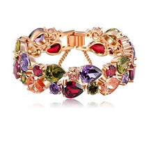 This rose gold bracelet features a wide variety of colours and crystals surrounding the piece. The crystals are two wide with one big and one small, alternating along the bracelet. The colours vary from green, purple, amber and red.