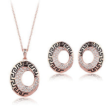  This set features a necklace and earrings with the same pendant/design. It is a long circle in shape, with one small, offset hole through it to the right hand side. Although on the left earring the design is mirrored. Around the outside of the circle is a black line which makes rectangular arches. The inner ring features small crystals for some added shine.